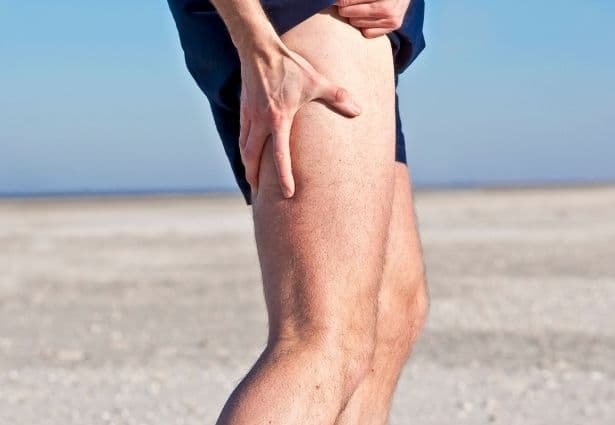 runner holding his leg due to muscle shrinking